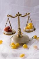 delicate still life with yellow and red cherry plum berries on marble antique scales photo