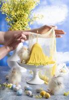 a woman lights a candle on a traditional yellow Slavic Easter curd cake photo