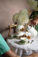 té descanso en el Inglés estilo, todavía vida con flores y rosquillas en el Mañana foto