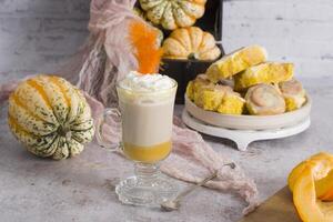 pumpkin cinnabons and latte for dessert, holiday table with pastries, home sweet photo