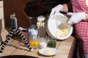 woman cooking spinach muffin step by step, pouring sugar into a bowl photo