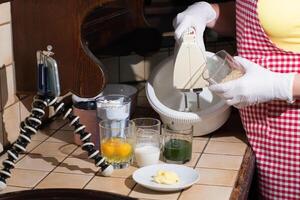 woman cooking spinach muffin step by step, pouring sugar into a bowl photo