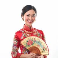 AI generated A woman in a red and gold Chinese dress stands holding a brown and orange fan. photo