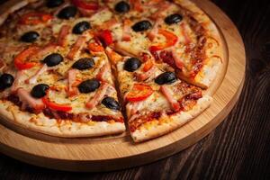 Ham pizza on wooden board close up photo