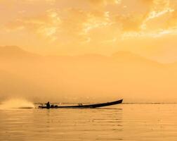 Motor boat silhouette on Inle lake photo