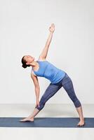 Woman doing yoga asana utthita trikonasana photo