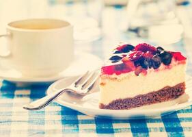 Cake on plate with fork and coffee cup photo