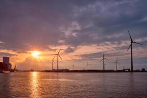 viento turbinas en Amberes Puerto en puesta de sol. foto