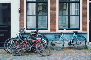 Bicecles which are a very popular transport in Netherlands parked in street near old houses photo