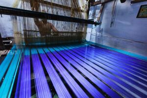 Man weaving silk sari on loom in India photo