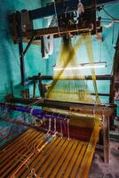 Man weaving silk sari on loom in India photo