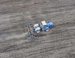 el tractor arados el campo. debajo siembra, el suelo es aflojado en el campo. foto