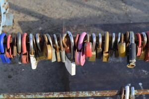 Love locks hung by newlyweds and lovers on the fence near the river. A symbol of strong relationships and eternal love photo