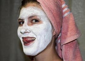 Cosmetic white face mask of toothpaste. Woman in white cosmetic mask photo