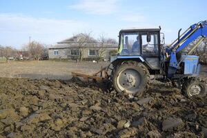 Tractor plowing the garden. Plowing the soil in the garden photo