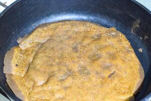 Frying pancakes on rye flour without butter in a pan with non stick coating photo