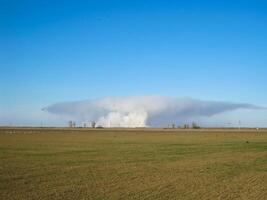 A pillar of smoke from burning rice straw on the field. photo