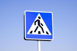 A pedestrian crossing sign. Sign on a blue sky background. photo