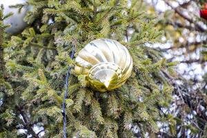 decoraciones nuevo año árbol. oropel y juguetes, pelotas y otro decoraciones en el Navidad Navidad árbol en pie en el abierto aire. foto