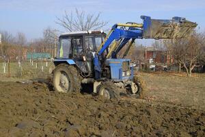 Tractor plowing the garden. Plowing the soil in the garden photo