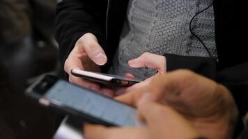 dichtbij omhoog van handen met mobiele telefoon en dagboek. zakenlieden gebruik makend van naar telefoon dichtbij omhoog video