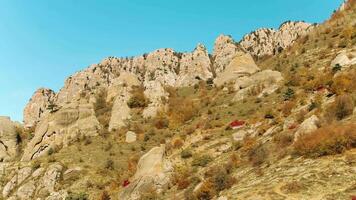 oben Aussicht von hoch Berg Angebot im bunt Herbst mit Grün Gelb Wiesen und felsig Berg Spitzen. Schuss. Aussicht von felsig Terrain von Berge. großartig Berg Landschaft gegen klar Blau Himmel video