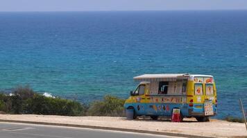 hielo crema autobús en el playa. color autobús con hielo crema cerca el mar en un caliente día video