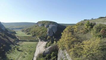 Haut vue de des loisirs centre dans vallée de Roche montagnes. tir. panorama de vallée de gorge rocheux rebords avec jardins de des arbres et Maisons video