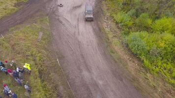Top view of SUVs driving on country road. Clip. Off-road race on rural forested area on dirty ground video