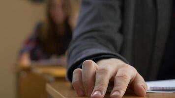 estudiante mano dedo tocando de cerca. joven hombre grifos su dedos en un mesa video