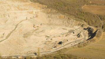 Top view of working quarry. Shot. Sand pit with escalators and buldozeri in open woodland. Mining concept video