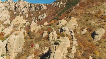 Top view of the mountain range. Shot. Top view of rock ledges. Mountain landscape with yellow and green grass between rock formations on clear autumn day video