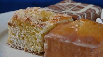 Cakes with cherry on a white plate on wooden boards. different pastries. Cakes video