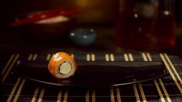 ett röd fisk rulla på tallrik. rulla med lax. sushi med flygande fisk. japansk mat på en skön maträtt. diet mat video