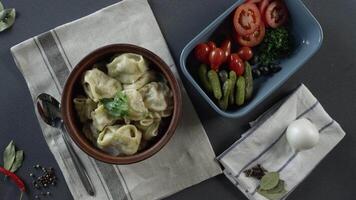 Nahansicht von Teller mit Knödel. Szene. Nahansicht von ein Teller von Knödel. oben Aussicht von rustikal Abendessen von Knödel und geschnitten Gemüse auf grau Tabelle und Besteck video