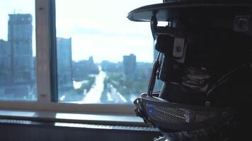 Close-up of detailed robot head of men in hat. Footage. Close-up of robot head in hat sitting on background of panorama of skyscrapers of city video