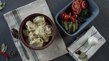 Nahansicht von Teller mit Knödel. Szene. Nahansicht von ein Teller von Knödel. oben Aussicht von rustikal Abendessen von Knödel und geschnitten Gemüse auf grau Tabelle und Besteck video