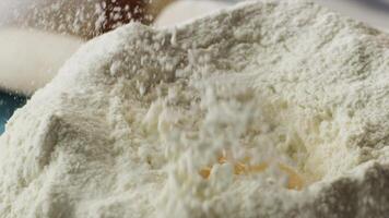 Close-up of egg in flour. Scene. Concept of cooking. Preparation of homemade cakes from white flour video