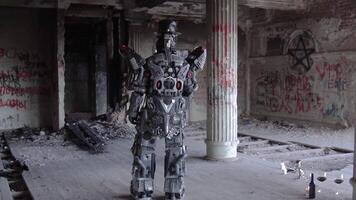 Humanoid robot stands with his back in hat in abandoned building. Footage. Android on date with glasses and bottle of wine stands back against gray walls with graffiti video