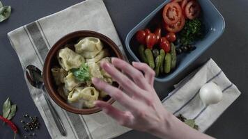 Nahansicht von Teller mit Knödel. Szene. Nahansicht von ein Teller von Knödel. oben Aussicht von rustikal Abendessen von Knödel und geschnitten Gemüse auf grau Tabelle und Besteck video