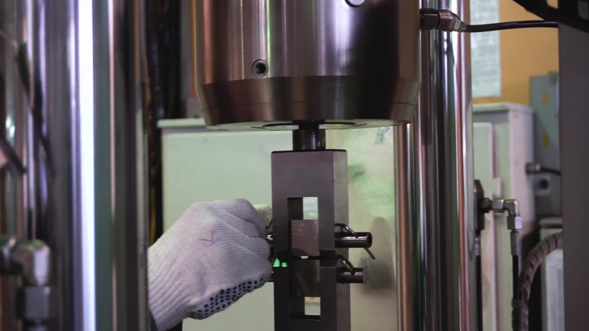Metal sample is tested for compressive strength. Footage. Close-up of ...