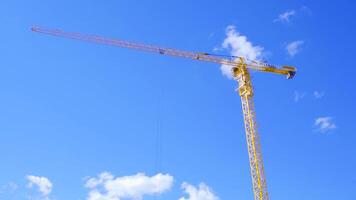 maquinaria grua construcción, herramienta de edificio industria. amarillo construcción grua en azul cielo antecedentes video
