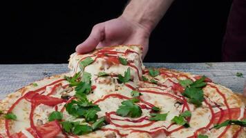 man tar en bit av pizza med hans hand. ram. manlig hand tar de skiva av pizza med elastisk ost video