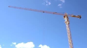 machinery crane construction, tool of building industry. Yellow construction crane on blue sky background video