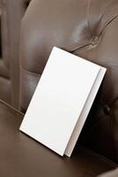 Book with blank cover on leather sofa photo