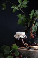 a jar of blackberry jam and bruschettas with soft cheese and berries photo