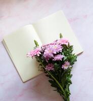 bouquet with pink gerberas and chrysanthemums and blank notebook photo