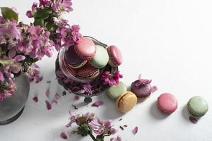 primavera todavía vida con de colores macarrones y rosado manzana árbol flores en un estaño foto