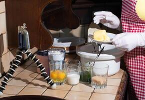 a woman prepares spinach muffins step by step, add butter to dough photo