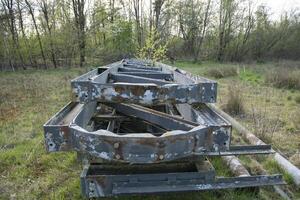 abandoned large metal structures with peeling paint in the middle of the forest photo